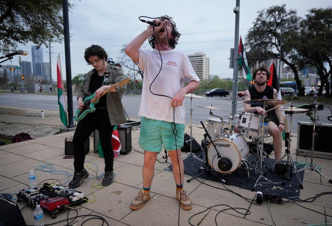 Belfast, Northern Ireland, band Enola Gay members, left to right, Joe McVeigh, Fionn Reilly and Luke Beirne perform at the Anti-SXSW Fest at City Hall Thursday March 14, 2024. The show featured several bands who boycotted SXSW in opposition to the U.S. Army being a sponsor.